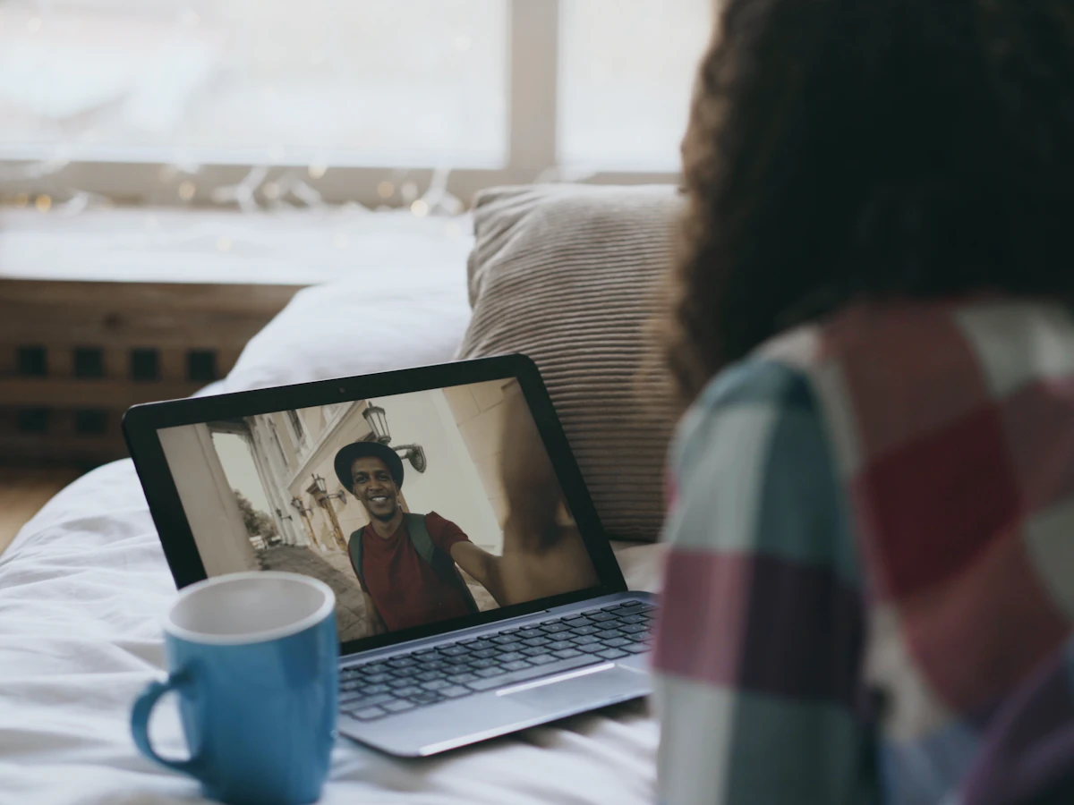 Kursantka rozmawia z lektorką przez kamerę w laptopie, obok kubek herbaty