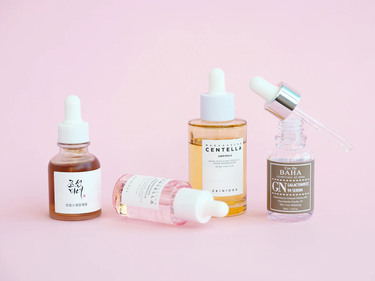 Buteleczki serum na różowym tle