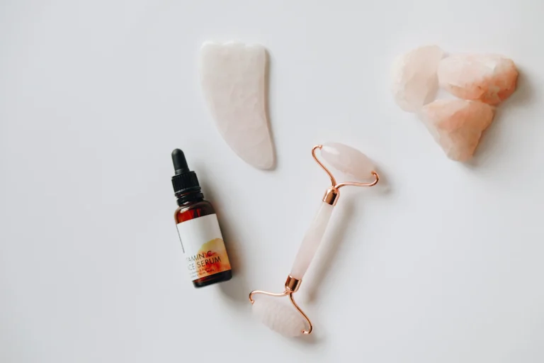 Serum, roller i kamień gua sha na jasnym tle